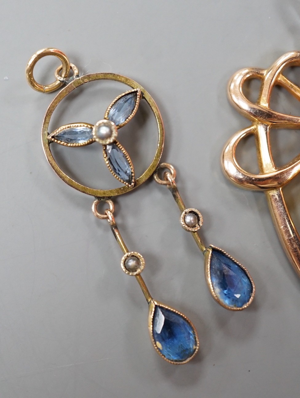 Three assorted early 20th century yellow metal and gem set pendants, including 9ct garnet and split pearl, largest overall 39mm, gross weight 5.2 grams.